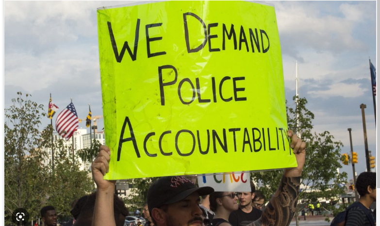 A person carrying a placard pushing for accountable law enforcement